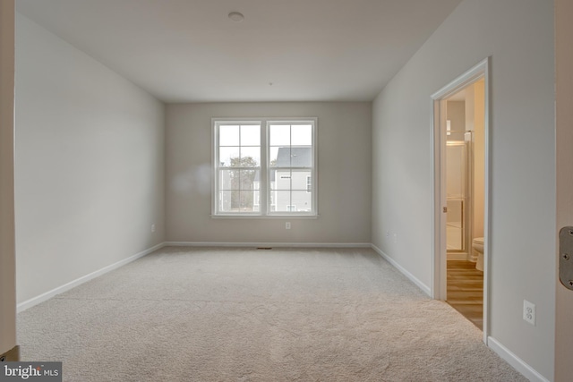 empty room featuring baseboards and carpet flooring