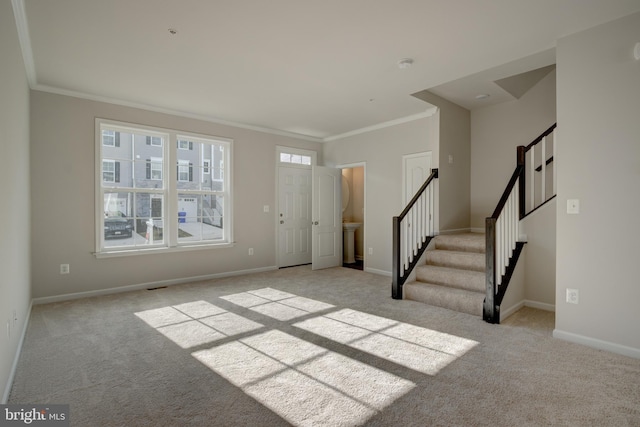 foyer entrance with stairs, ornamental molding, light carpet, and baseboards