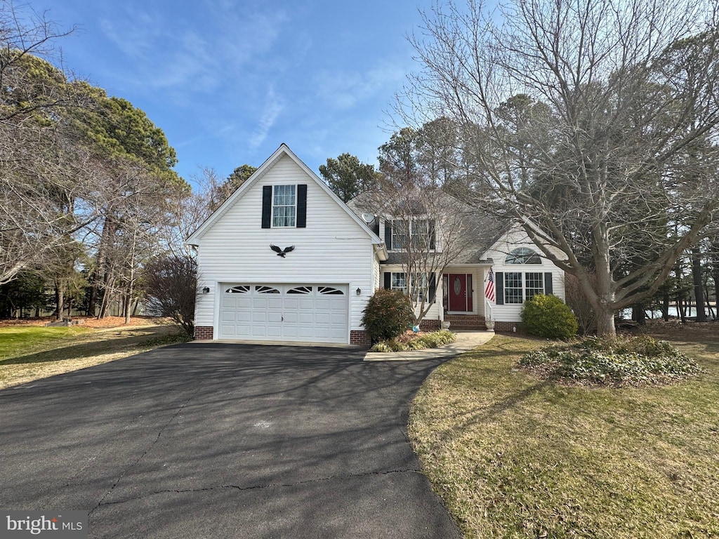 traditional home featuring aphalt driveway and a front lawn