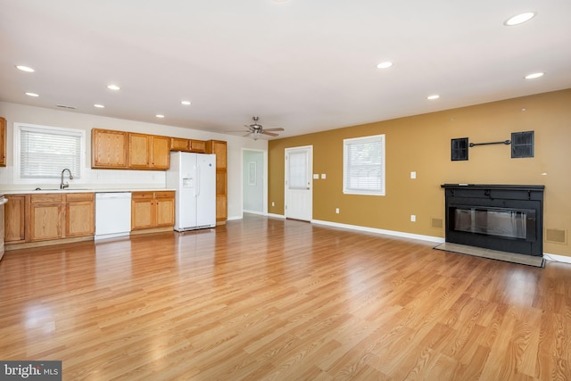 2115 Ruxton Dr, Salisbury, MD 21801 - unfurnished living room featuring healthy amount of natural light, recessed lighting, a glass covered fireplace, light wood finished floors, and a ceiling fan
