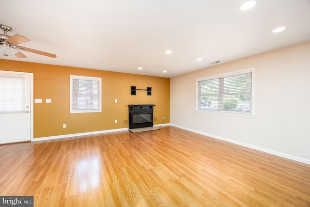 2115 Ruxton Dr, Salisbury, MD 21801 - unfurnished living room featuring a glass covered fireplace, light wood-style floors, recessed lighting, baseboards, and ceiling fan