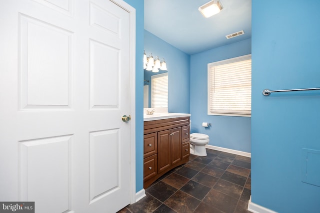 2115 Ruxton Dr, Salisbury, MD 21801 - bathroom with baseboards, toilet, vanity, and stone finish flooring
