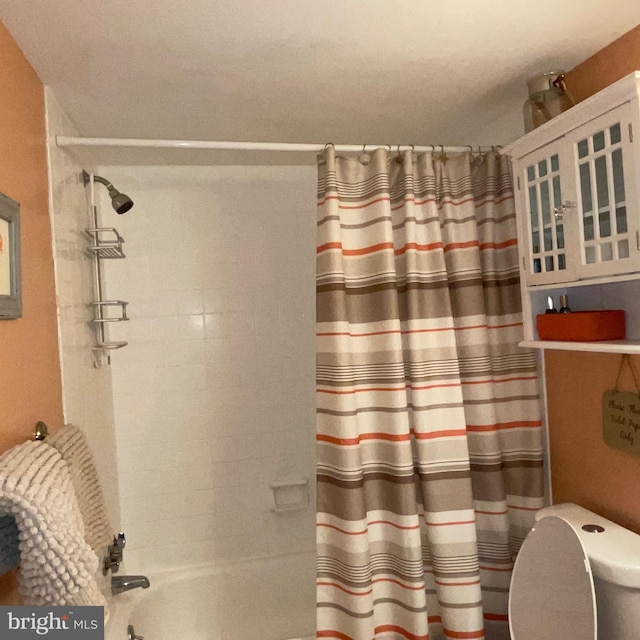 bathroom with toilet and shower / bath combo with shower curtain