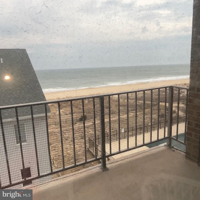 balcony featuring a water view and a beach view