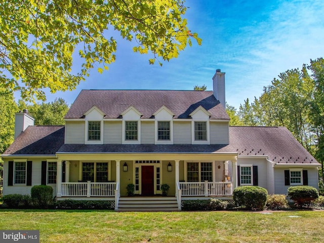 view of front of home featuring a front yard, covered porch, and a chimney