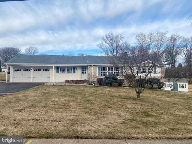 ranch-style house with driveway, a front lawn, and an attached garage