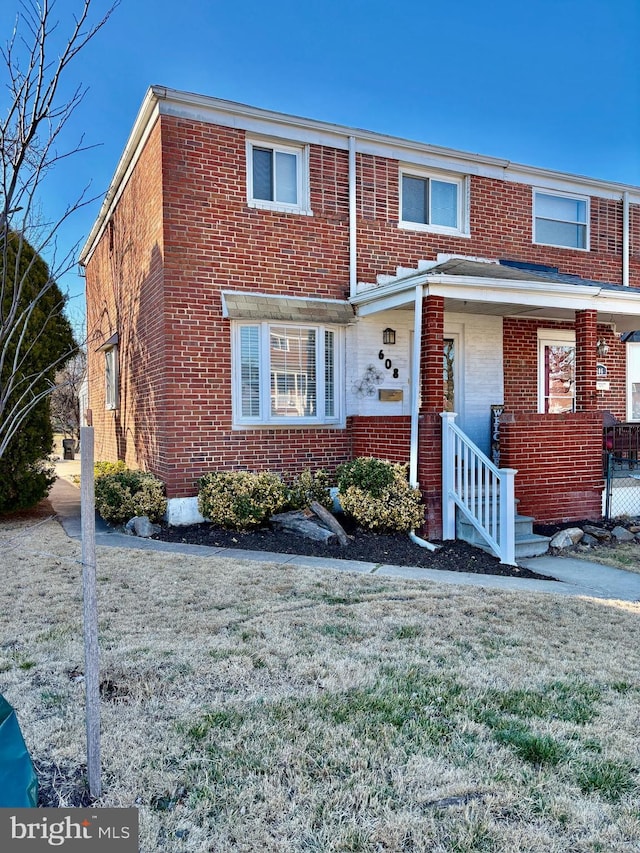 townhome / multi-family property featuring brick siding and a front yard