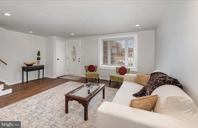 living room featuring stairs, baseboards, wood finished floors, and recessed lighting