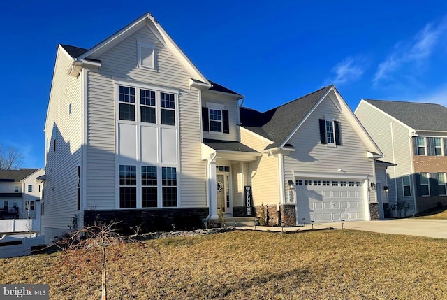 traditional-style home featuring driveway, stone siding, and an attached garage