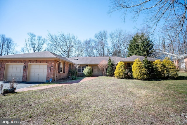 ranch-style home featuring a garage, brick siding, driveway, and a front lawn