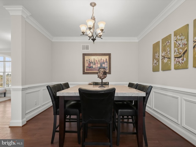 dining space featuring visible vents, a notable chandelier, ornamental molding, wainscoting, and dark wood-style flooring