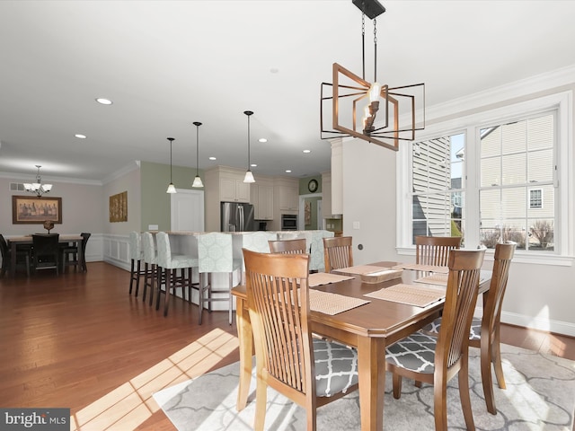 dining room with crown molding, recessed lighting, wood finished floors, and a chandelier