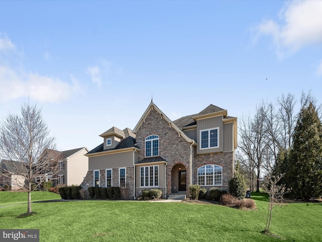 view of front of property with stone siding and a front lawn