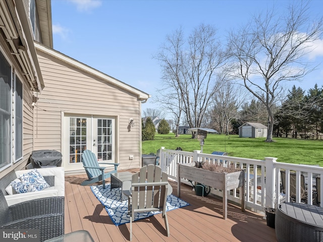 wooden terrace with a lawn, french doors, a storage shed, an outbuilding, and area for grilling