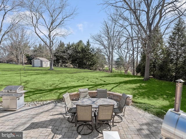 view of patio featuring outdoor dining area, grilling area, a storage shed, and an outdoor structure