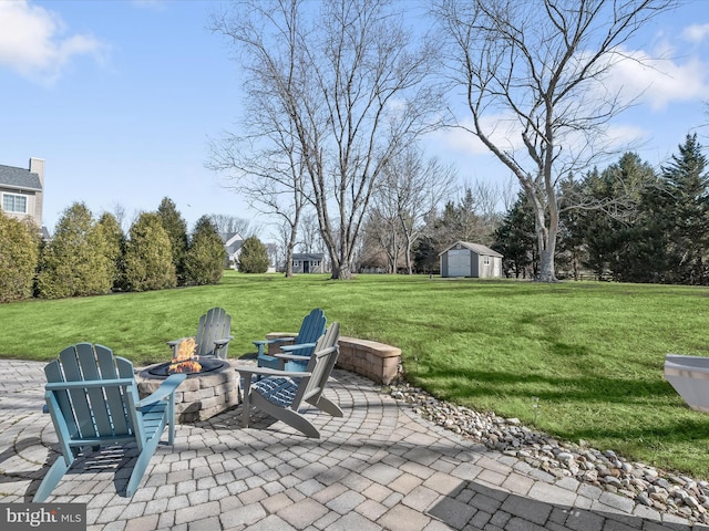 view of patio / terrace featuring a storage unit, an outdoor fire pit, and an outdoor structure