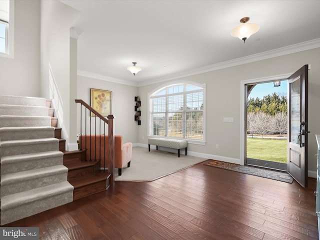 entryway featuring plenty of natural light, hardwood / wood-style floors, stairs, and ornamental molding