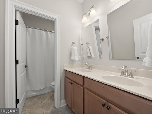 full bathroom featuring tile patterned flooring, double vanity, toilet, and a sink