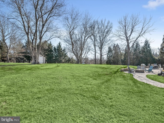 view of yard featuring a fire pit and a patio area