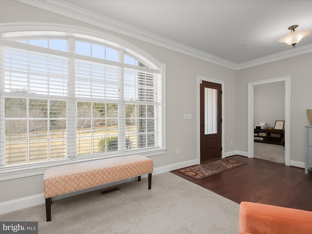 foyer featuring visible vents, wood finished floors, baseboards, and ornamental molding