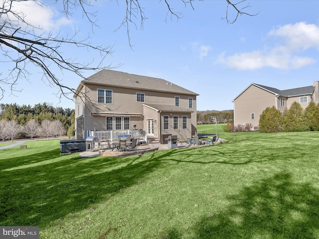 rear view of property featuring a lawn and a patio area