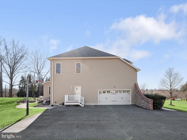 view of side of property featuring aphalt driveway, a lawn, and an attached garage