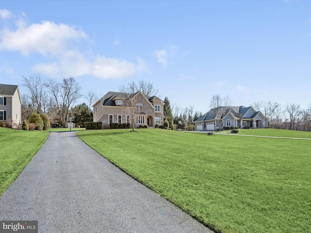 view of front of home with stone siding, an attached garage, and a front lawn