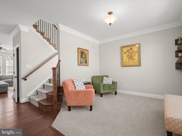 living area featuring stairway, baseboards, and crown molding