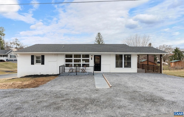 single story home featuring a porch, driveway, and a shingled roof