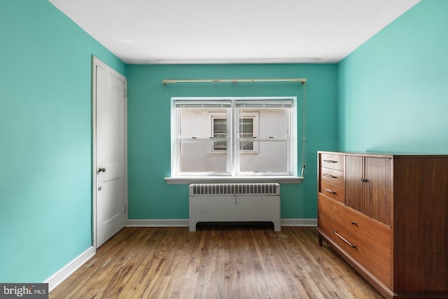 interior space featuring radiator, baseboards, and wood finished floors