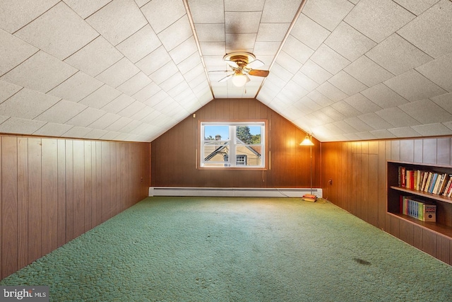 additional living space with lofted ceiling, carpet, wood walls, built in shelves, and a baseboard heating unit