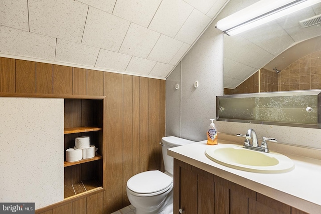 full bath with visible vents, toilet, a tile shower, vaulted ceiling, and vanity