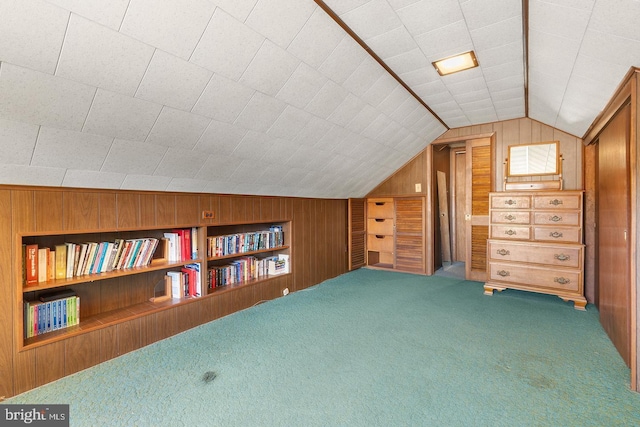 bonus room with built in shelves, carpet, vaulted ceiling, and wooden walls