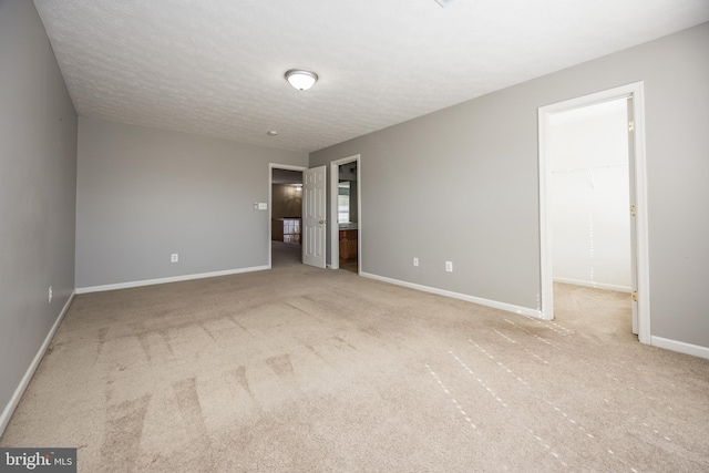 carpeted spare room featuring baseboards and a textured ceiling