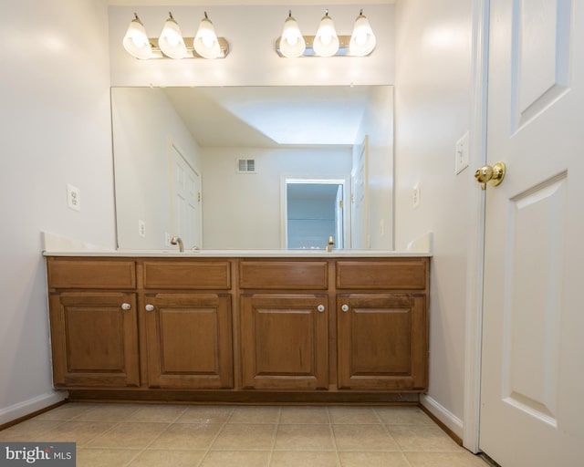 bathroom with double vanity, tile patterned flooring, visible vents, and baseboards