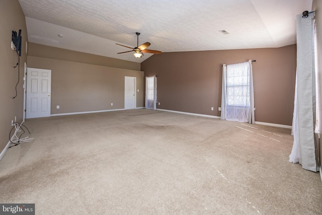 carpeted empty room with visible vents, baseboards, lofted ceiling, ceiling fan, and a textured ceiling