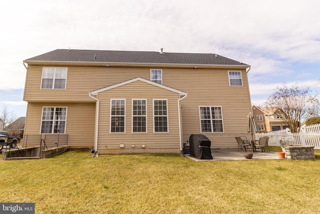 rear view of property featuring a patio area, fence, and a yard