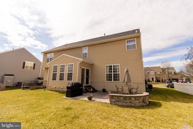 back of house featuring entry steps, a patio area, fence, and a lawn