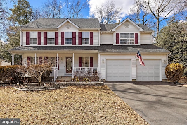 view of front of house with aphalt driveway, covered porch, roof with shingles, and an attached garage