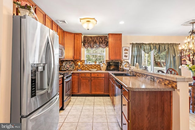 kitchen with visible vents, decorative backsplash, appliances with stainless steel finishes, a peninsula, and a sink