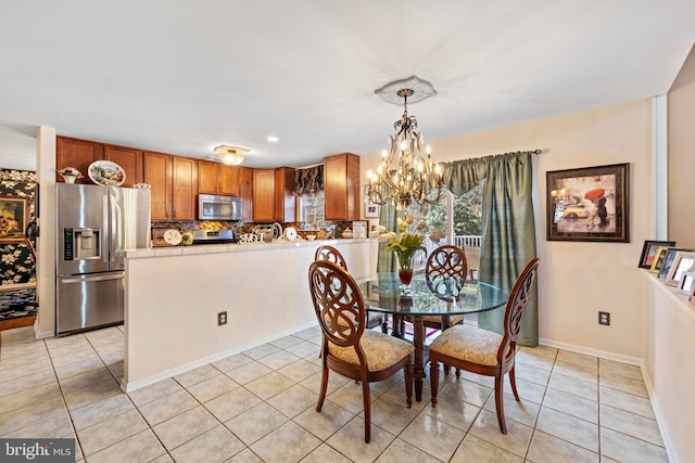 dining room featuring light tile patterned floors, baseboards, and an inviting chandelier