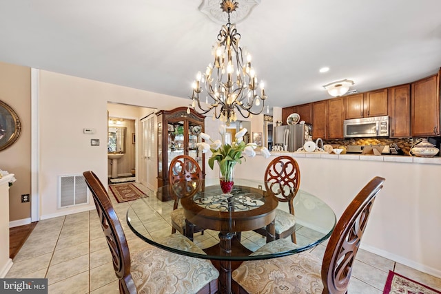 dining area featuring light tile patterned flooring, visible vents, and baseboards