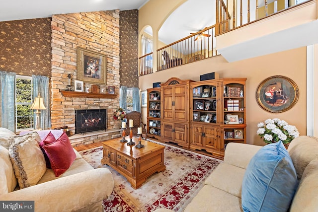 living area with a fireplace, a high ceiling, and wood finished floors