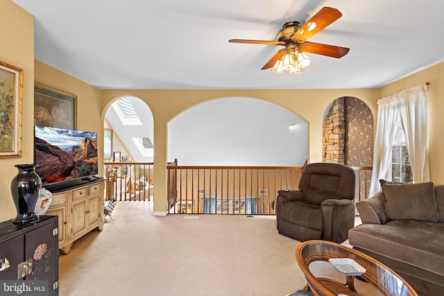 living area with ceiling fan, a skylight, and carpet flooring