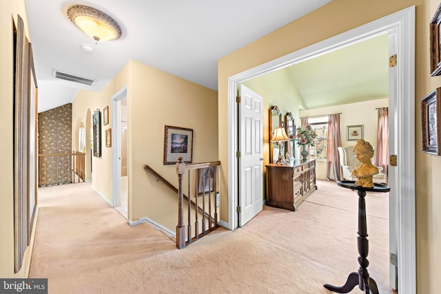 hallway featuring visible vents, carpet flooring, an upstairs landing, and baseboards