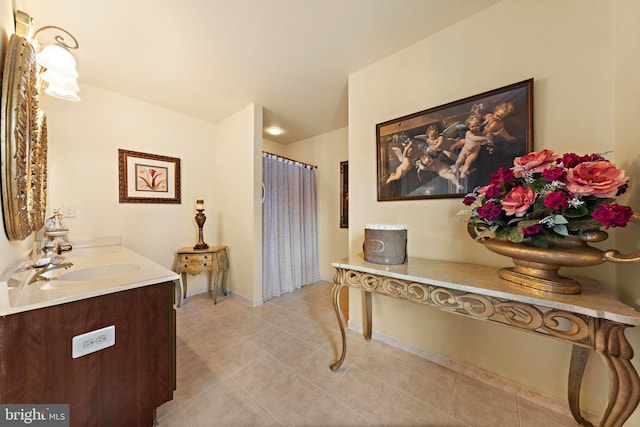 bathroom with curtained shower, tile patterned flooring, vanity, and baseboards