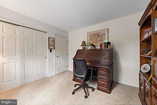 carpeted office space featuring baseboards