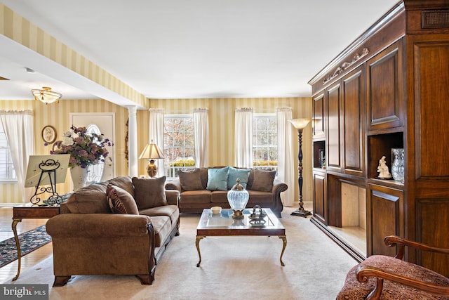 living area with ornate columns and wallpapered walls