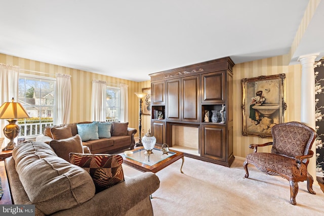 living area featuring light carpet, ornate columns, and wallpapered walls