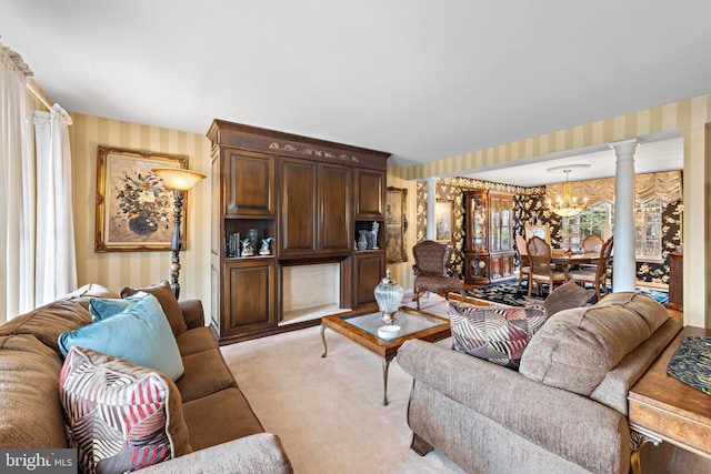 living room featuring a chandelier, light carpet, decorative columns, and wallpapered walls